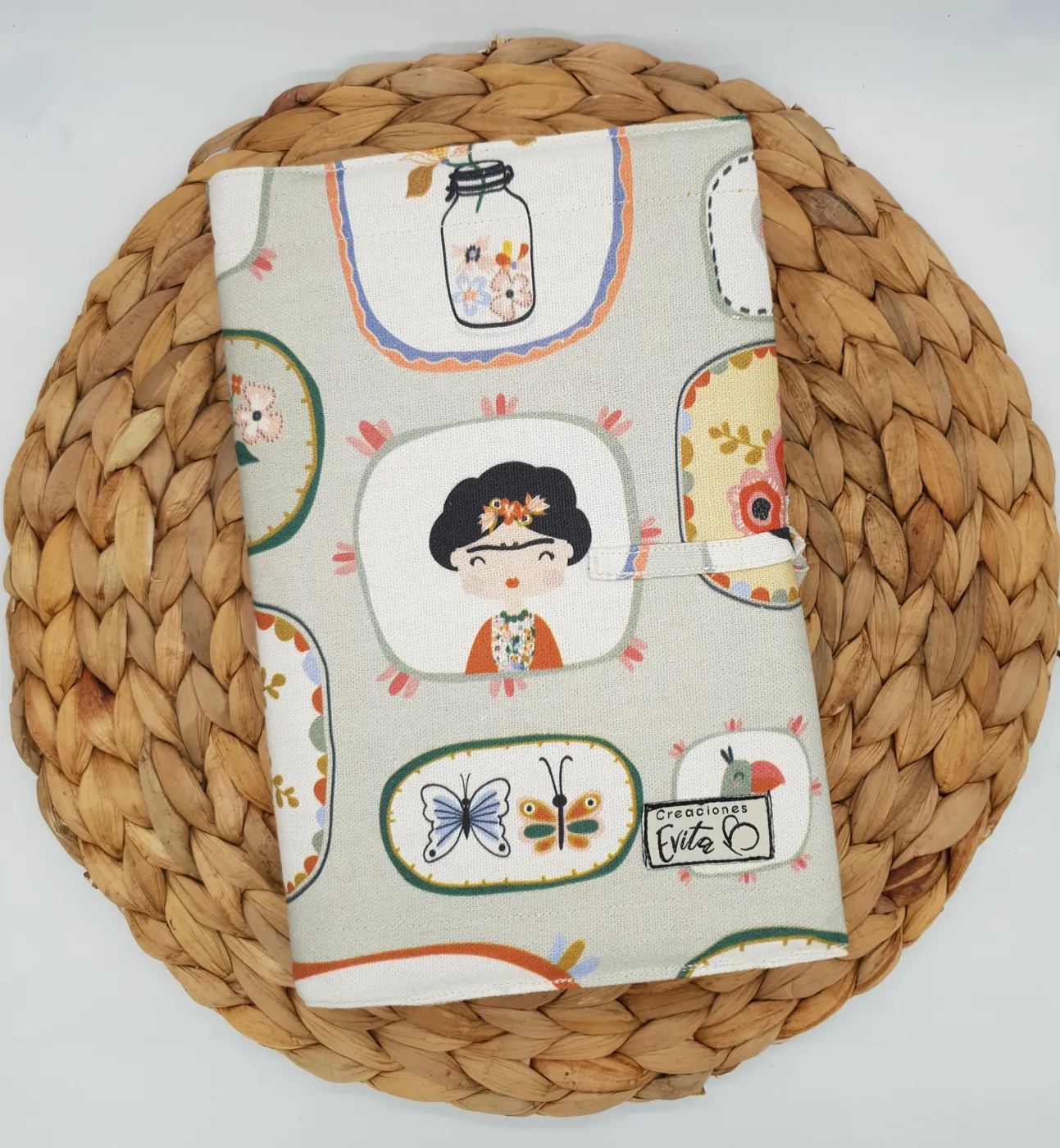 Funda de tela Frida Lover con ilustraciones sobre un posavasos de mimbre